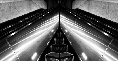 Mirrored escalator, converging light rails